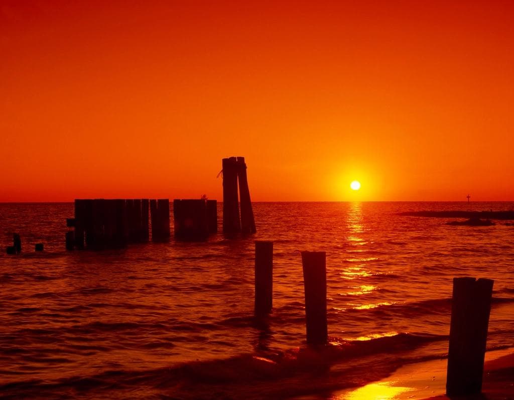 Sunset over the Chesapeake Bay with old pilings standing in shallow water