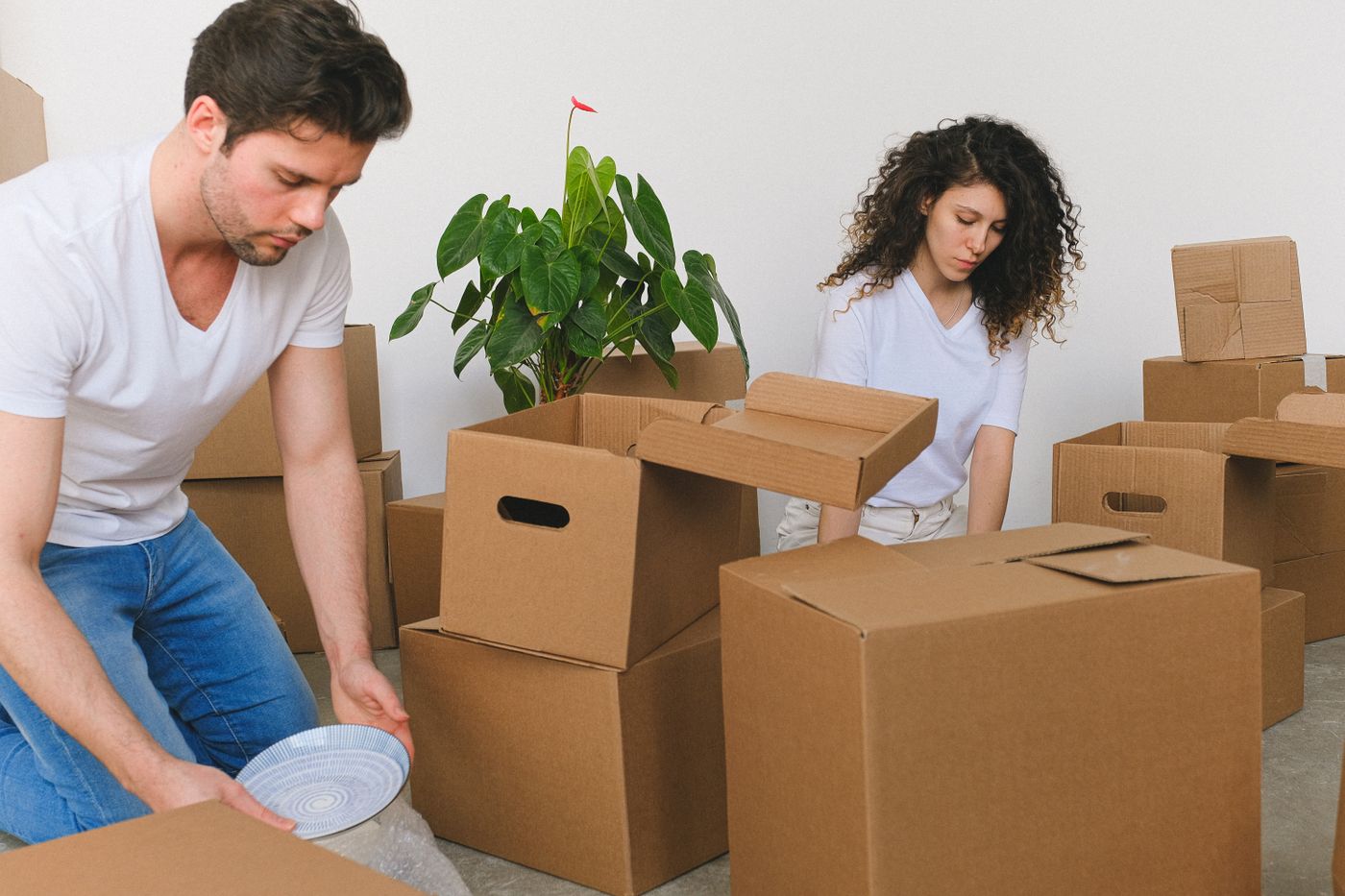 Moving boxes stacked in a bright hallway, front door open to sunlight