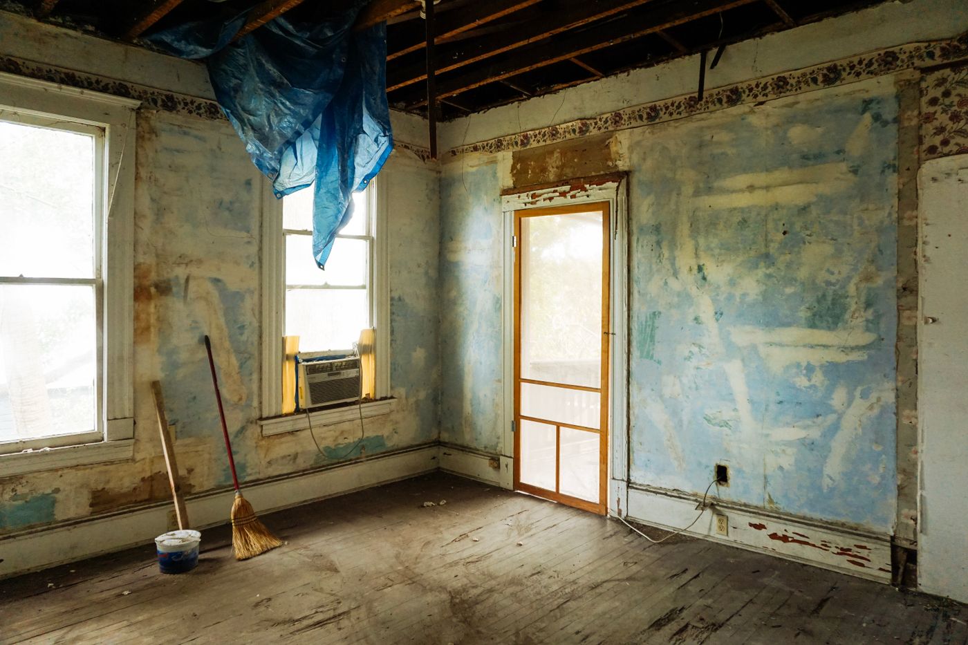 A house with a sagging porch and weathered siding — sold as-is, no judgment